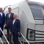 Le ministre Kamel al-Wazir pose à côté d'un train à grande vitesse