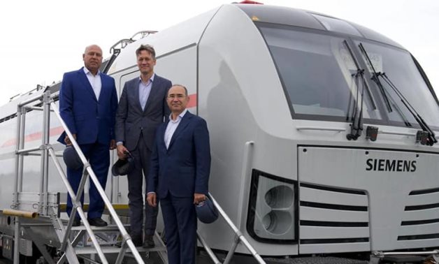 Le ministre Kamel al-Wazir pose à côté d'un train à grande vitesse