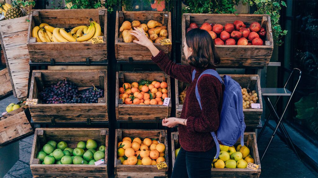 jeune parcourant un étal de fruits