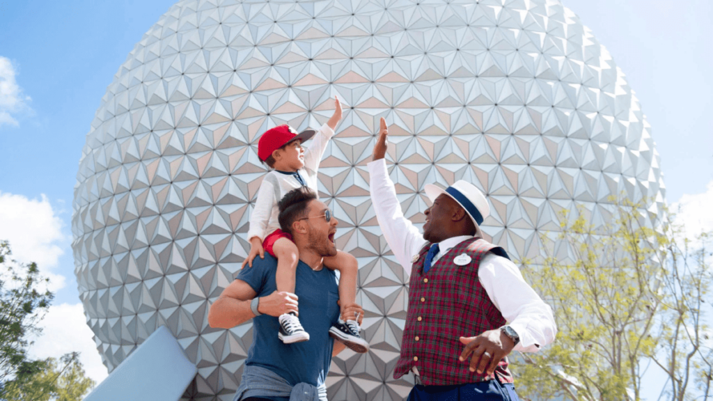 Un membre de la distribution en costume de guide touristique VIP félicitant un enfant et son père devant le vaisseau spatial Terre à EPCOT